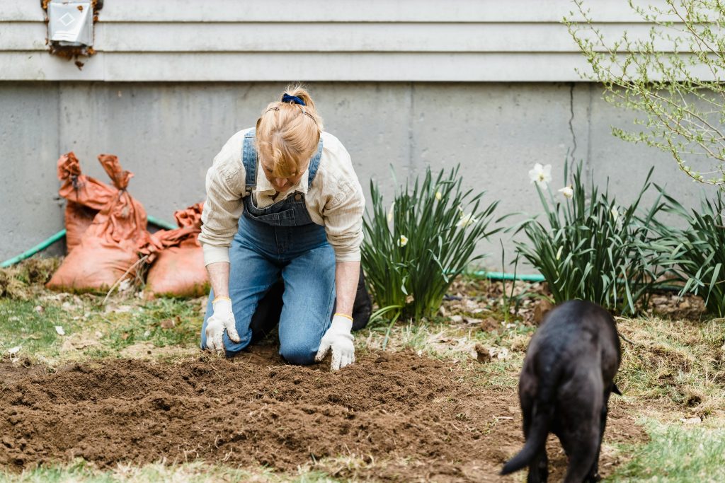 Woman working with soil in garden // Healthier Pets Today