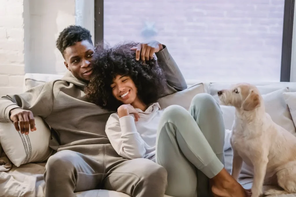 Romantic black couple chilling on couch with dog // Healthier Pets Today