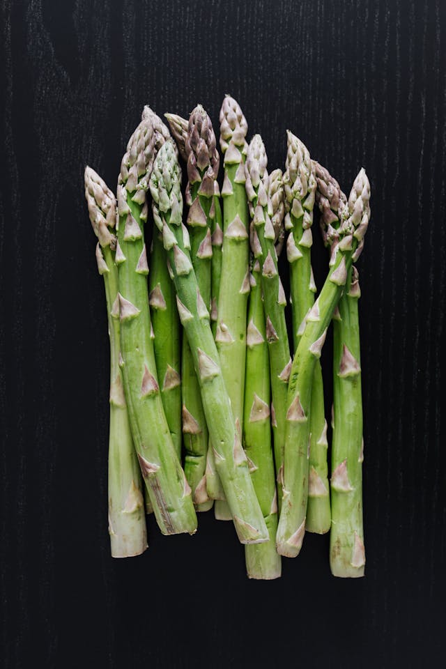 Bunch of fresh green asparagus on dark table // Healthier Pets Today
