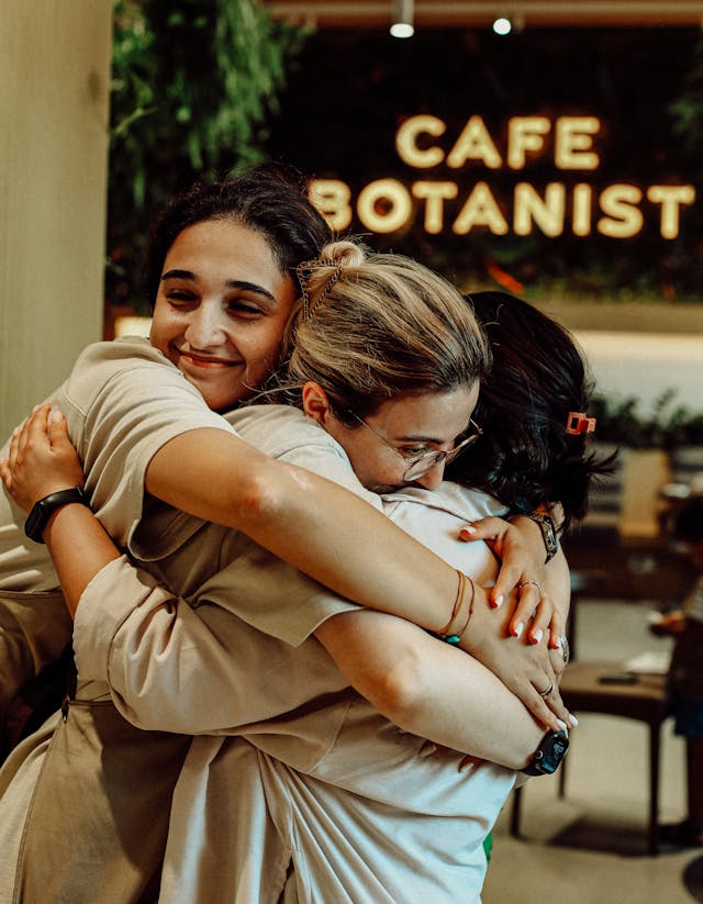 Women Hugging in Cafe // Healthier Pets Today